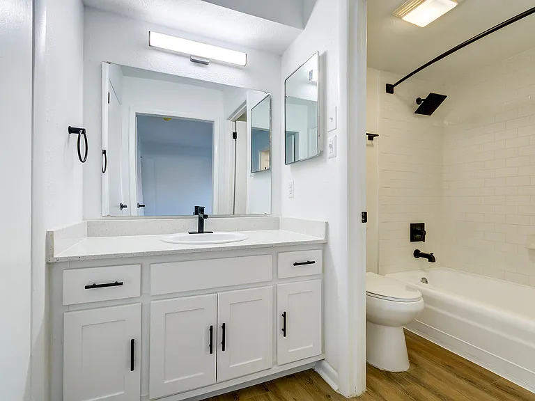 A newly renovated bathroom with white cabinetry and black finishes is shown at ReNew on Cantrell.