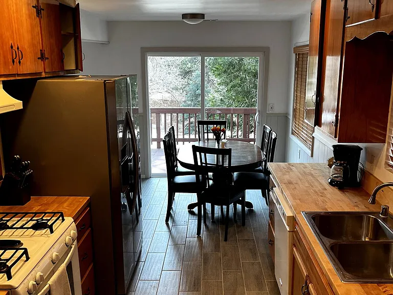 Kitchen open to dining with side deck access.