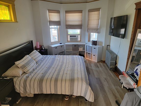 Main bedroom with walk in closet. Great sun and view of street, access to covered front porch.