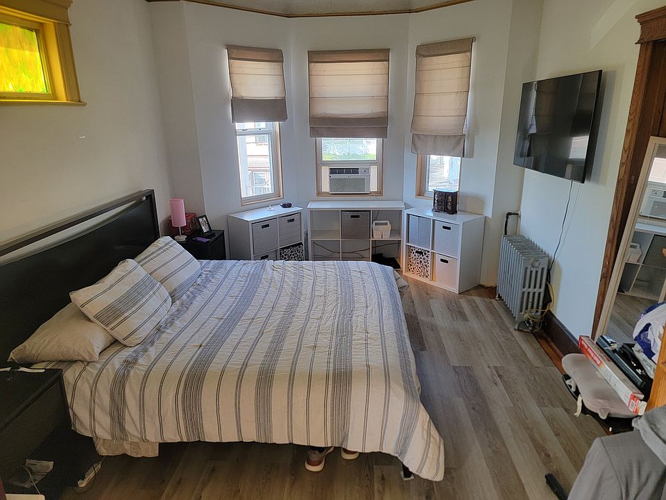 Main bedroom with walk in closet. Great sun and view of street, access to covered front porch.