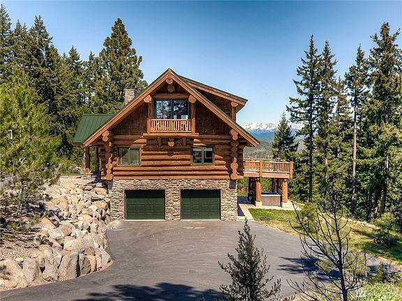Full view of the back of the house featuring large terracing stones on paved driveway