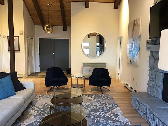 Living room from other side. Wireless Smart TV. Large mirror reflects lake.