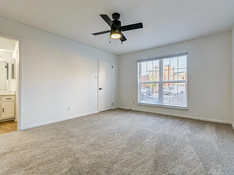 A bright living room with ceiling fan and vinyl floor is shown at ReNew on Cantrell.