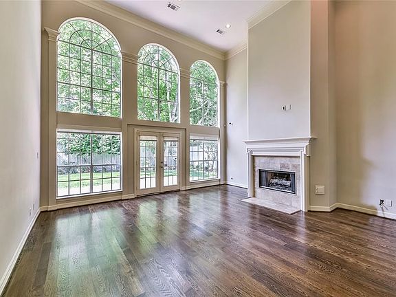 Grand two story Family Room with a wall of arched windows and French doors leading to patio and spacious backyard large enough for kids, pets and a pool!