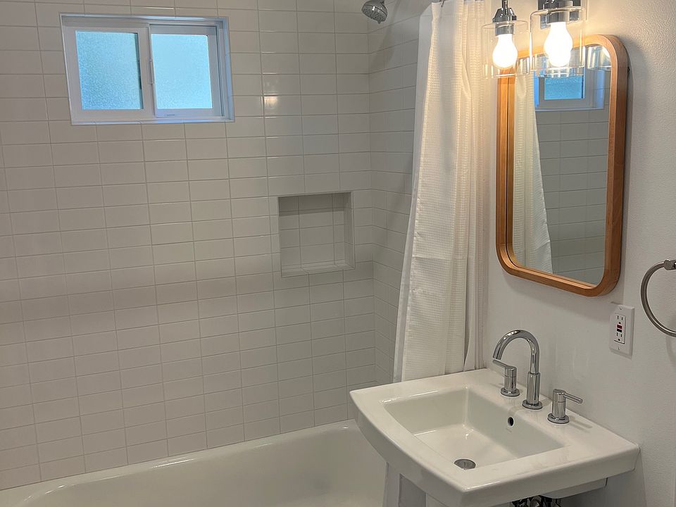 Bathroom, with subway tile walls, niche, tile floors, pedestal sink.