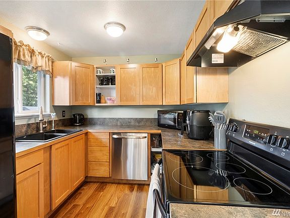 New kitchen with maple cabinets, sink, stove and floor.