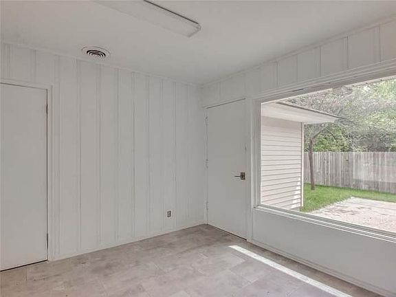 Utility room looking out to backyard. Utility room connects garage and kitchen, houses washer and dryer.
