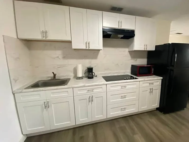 Fully equipped kitchen with fridge, microwave, coffee maker, and essentials