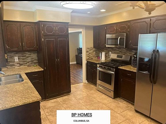 Kitchen with gas stove, microwave, and refrigerator