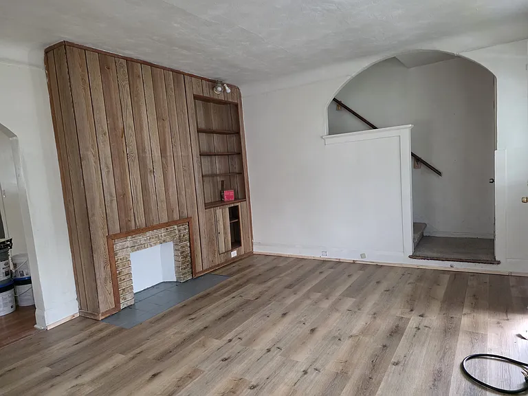 SPacious living room with faux fireplace and built in bookcases
