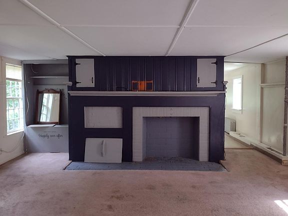 Living room, with updated carpets. Stairs to upstairs to the left, door to the kitchen on right in photo