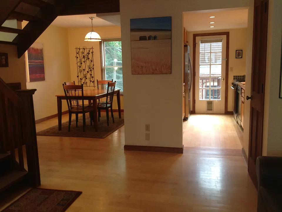 View from vaulted ceiling living room into dining room and kitchen.