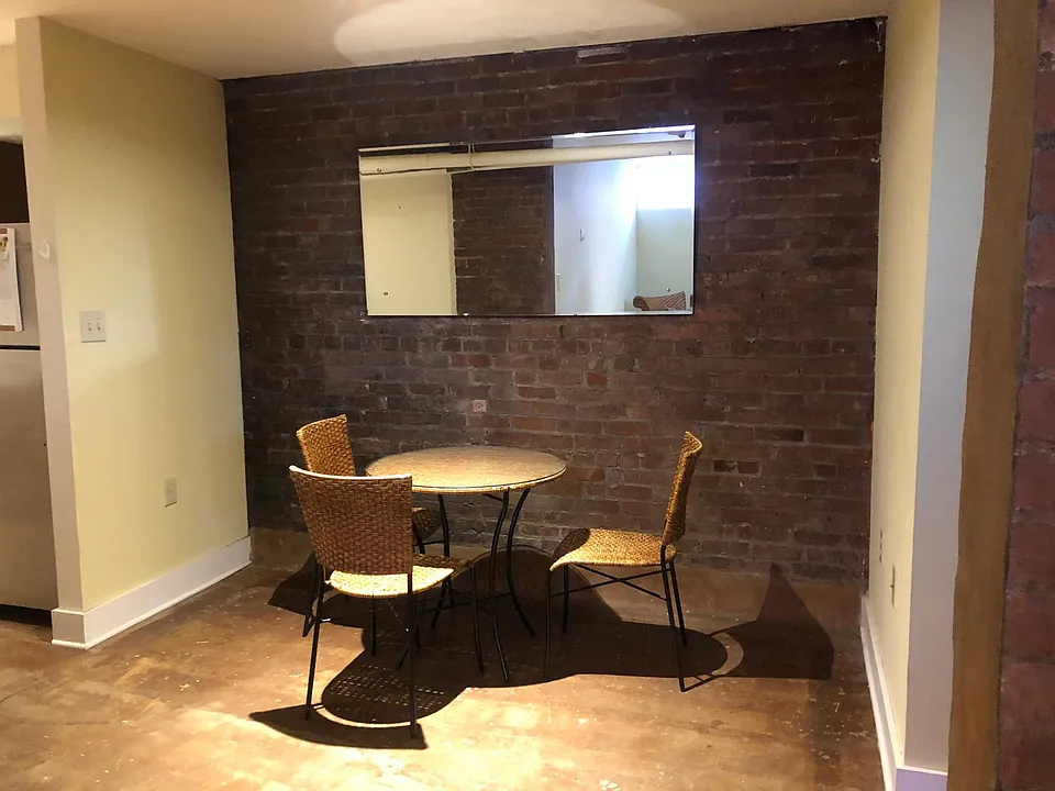 Dining area. Large mirror reflects the light from the window in the living room.