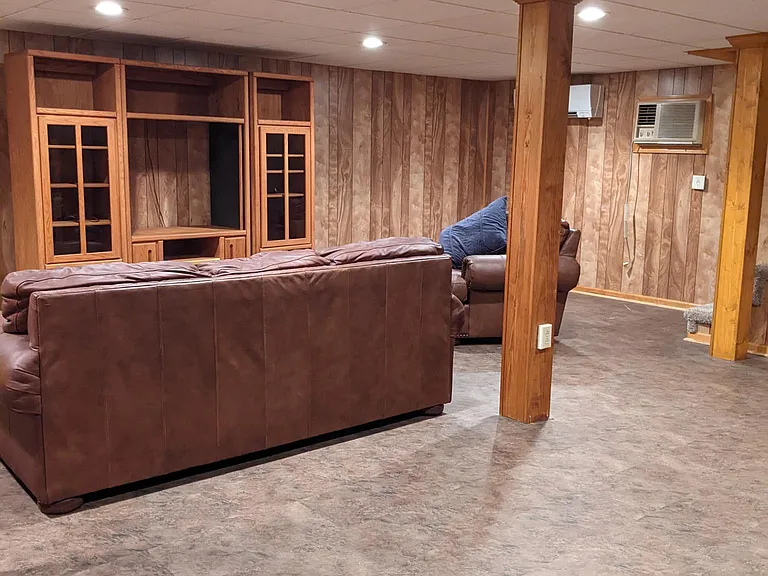 Basement (furniture not included); photo taken prior to renovations.