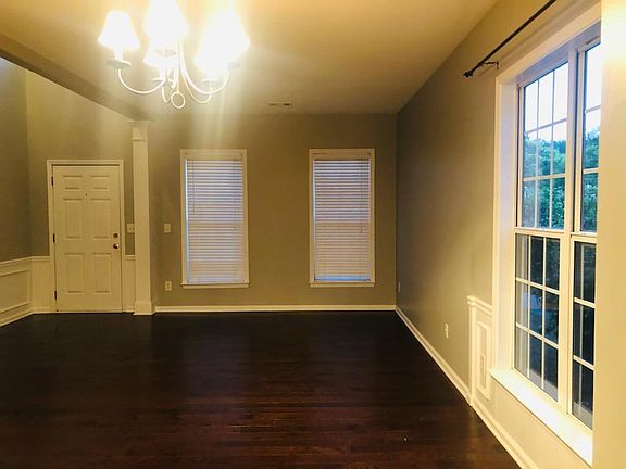 Large formal dining/living area at front entrance with high ceilings, windows on two walls letting in plenty of light and fresh air