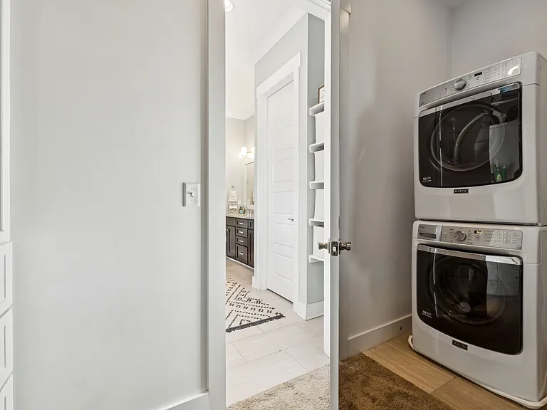 Ensuite bath to primary bedroom, with walk-in closet and laundry area.