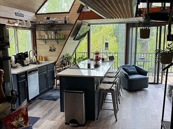 View of the kitchen island, stove, oven, dishwasher, sink.