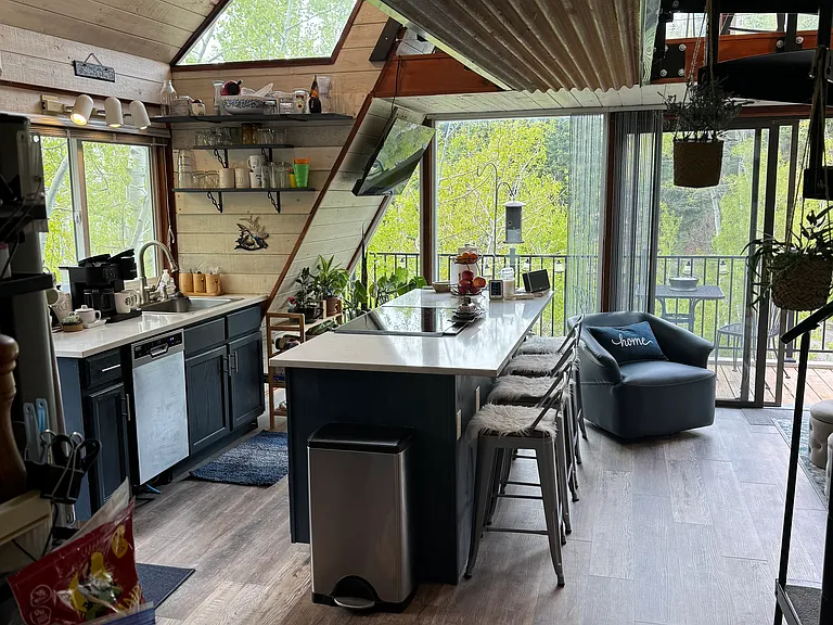 View of the kitchen island, stove, oven, dishwasher, sink.