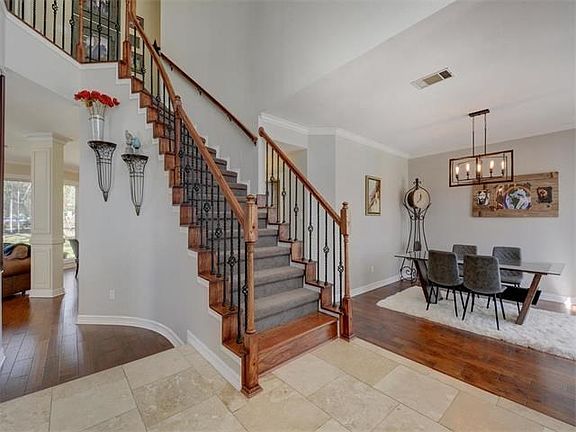 Bright, airy dining room on the other side of the wide foyer.  This is one of two staircases leading to the upstairs.