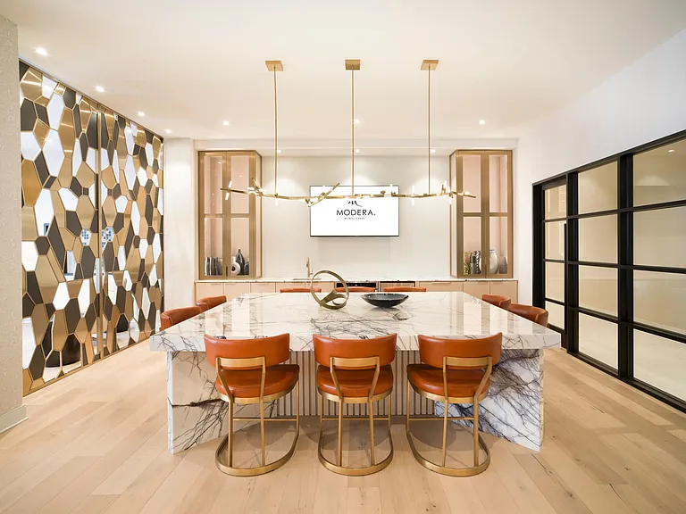 A refined clubroom kitchen with a marble island and bar seating, designed for hosting gatherings or enjoying everyday moments in a polished setting.
