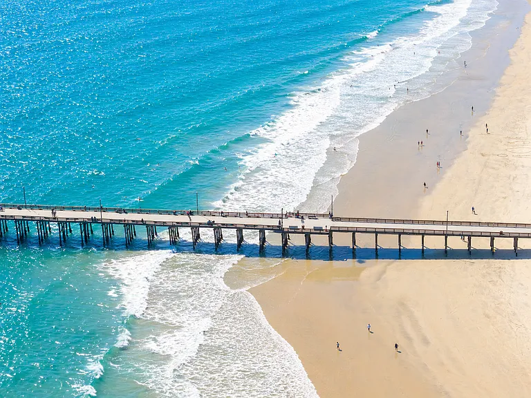 Pier and shoreline with clear blue coastal waters