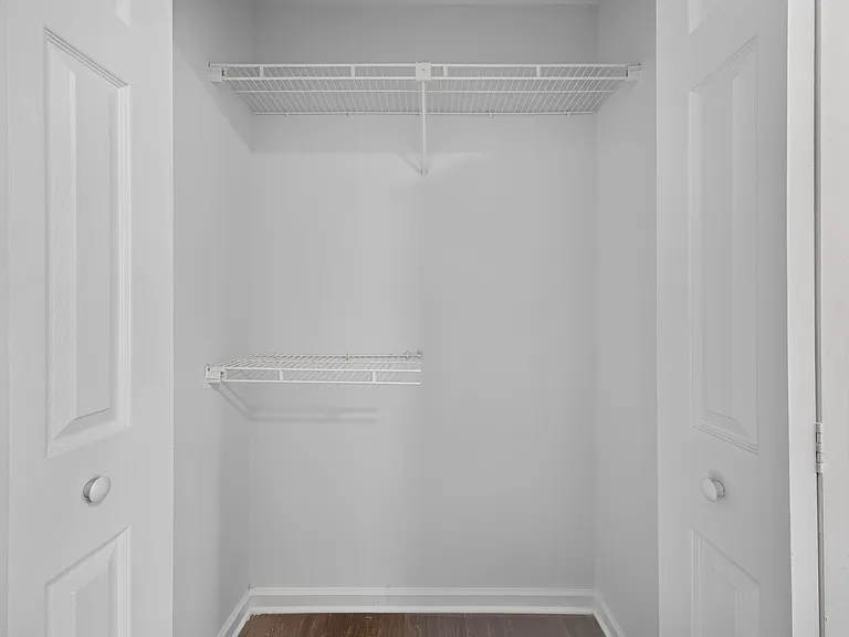 Walk-in closet with double wire shelving and open floor space for easy organization and extra storage.