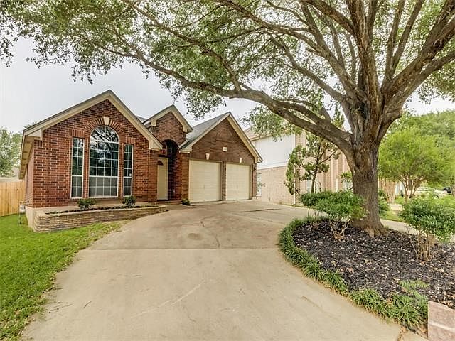 This is a 2.100 sq ft (TCAD) single story home with a unique drive way that curves around this stately tree.