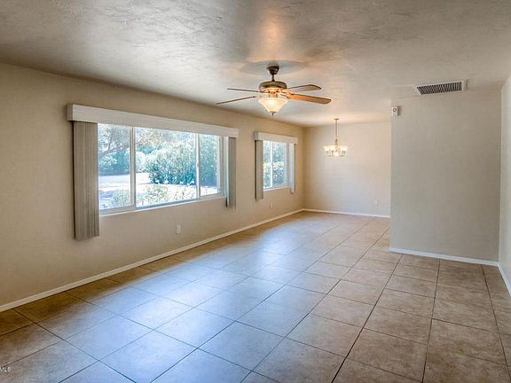 Living room and dining room; kitchen is off to the right from the dining room. Window coverings not included.