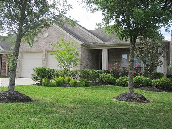 Nicely landscaped front yard with several trees and lush green grass add curb appeal.