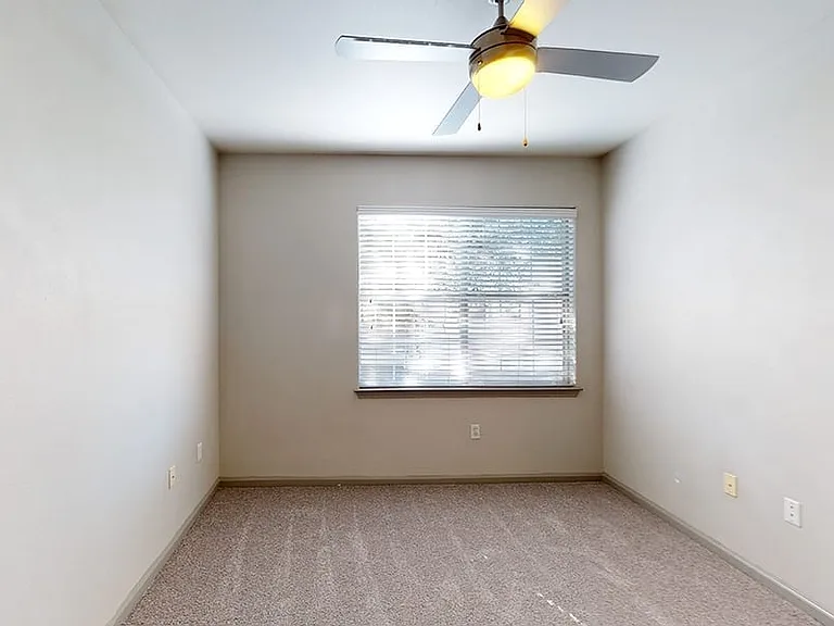 Spacious apartment bedroom with plush carpet flooring