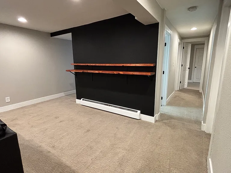 Living space includes new wooden shelves to complement bar stools or additional decor. In view is hallway to bathroom, wash room, bedroom 1 and bedroom 2 (office).
