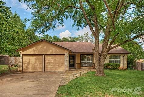 The front of the home features a lovely front porch, mature trees, and lots of shade.