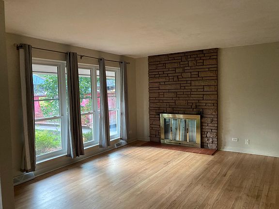 Standing by the hallway looking at the front window and fireplace