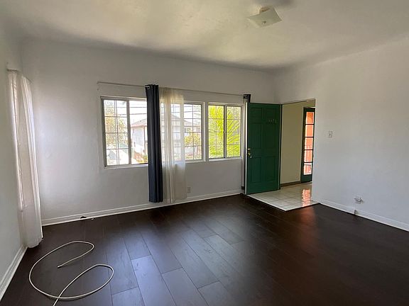 Entrance into the unit is a large living room with new wood flooring and blinds