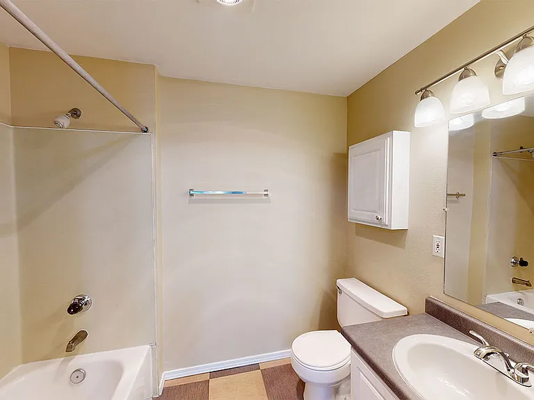 Apartment bathroom with tile flooring.