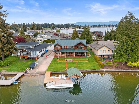 Entertaining is easy at your new lodge with covered back patio, level lawn space, dock, bulkhead, covered boat lift and private boat ramp