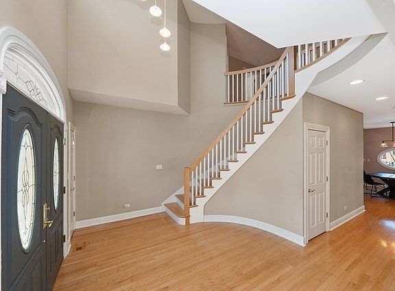 Two story entrance foyer with custom spiral staircase, maple hardwood floors throughout!