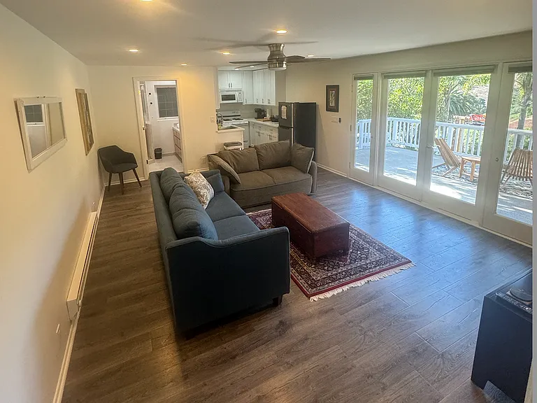 Living room has one full sized pull out sofa bed, smart TV wired with internet, and french doors opening onto a private deck