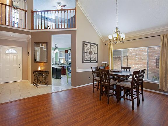 Tiled entry into the kitchen. The formal dining room has laminate flooring, dentil crown molding, chair rail and a wrought iron light fixture.
