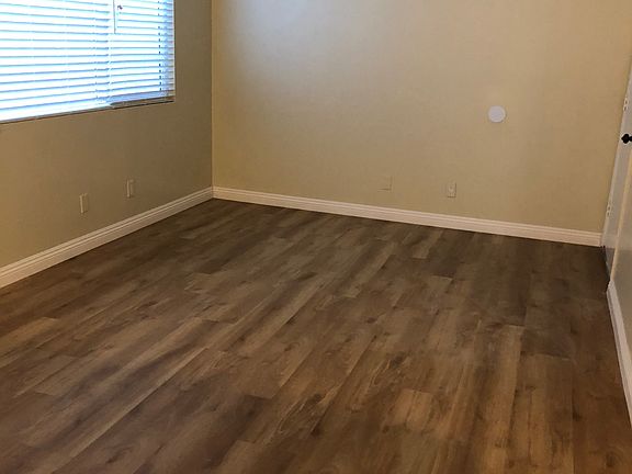 large Living Room with new laminate floor and crown baseboard, Venetian Blinds and newly painted