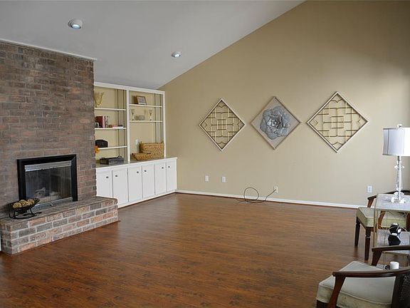 Brick fireplace is flanked by built-ins and storage along with a wet bar area for entertaining.