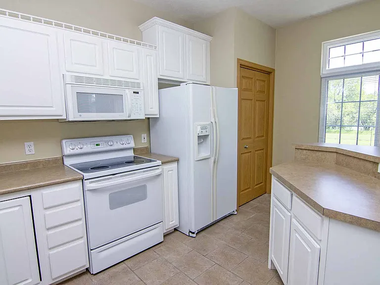 Bright kitchens with classic white cabinetry and plenty of counter space makes cooking effortless.