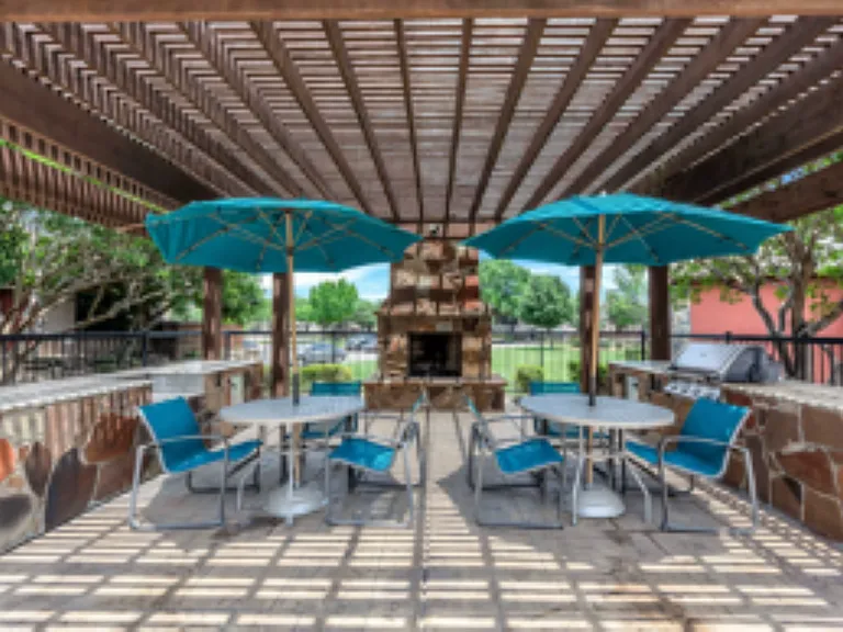 Expansive outdoor cabana with fireplace and grilling station.