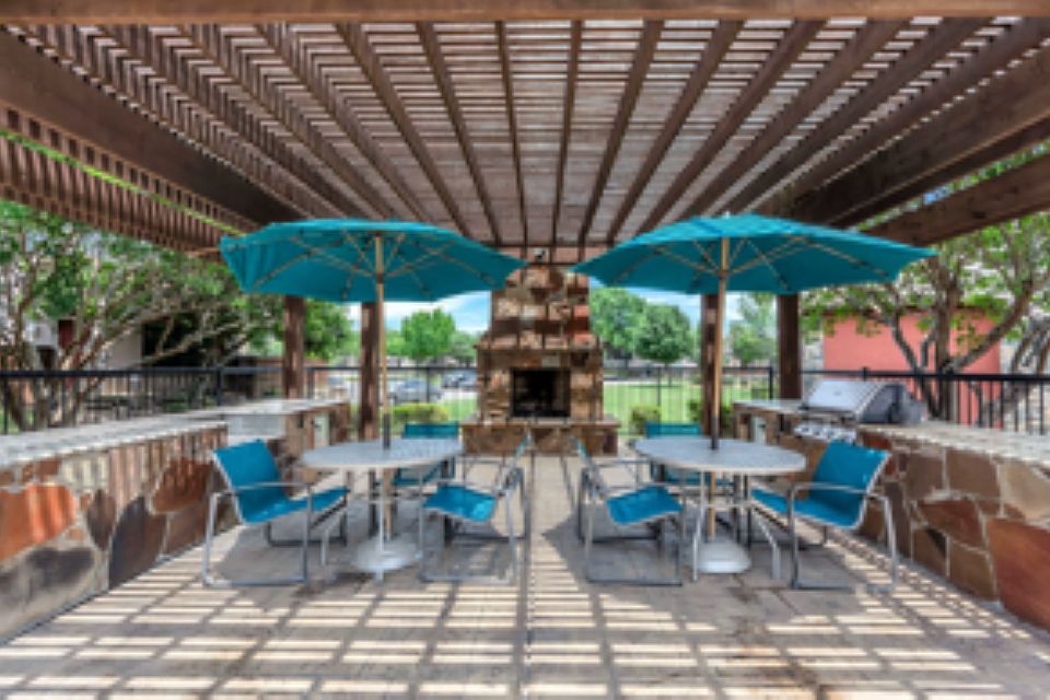 Expansive outdoor cabana with fireplace and grilling station.