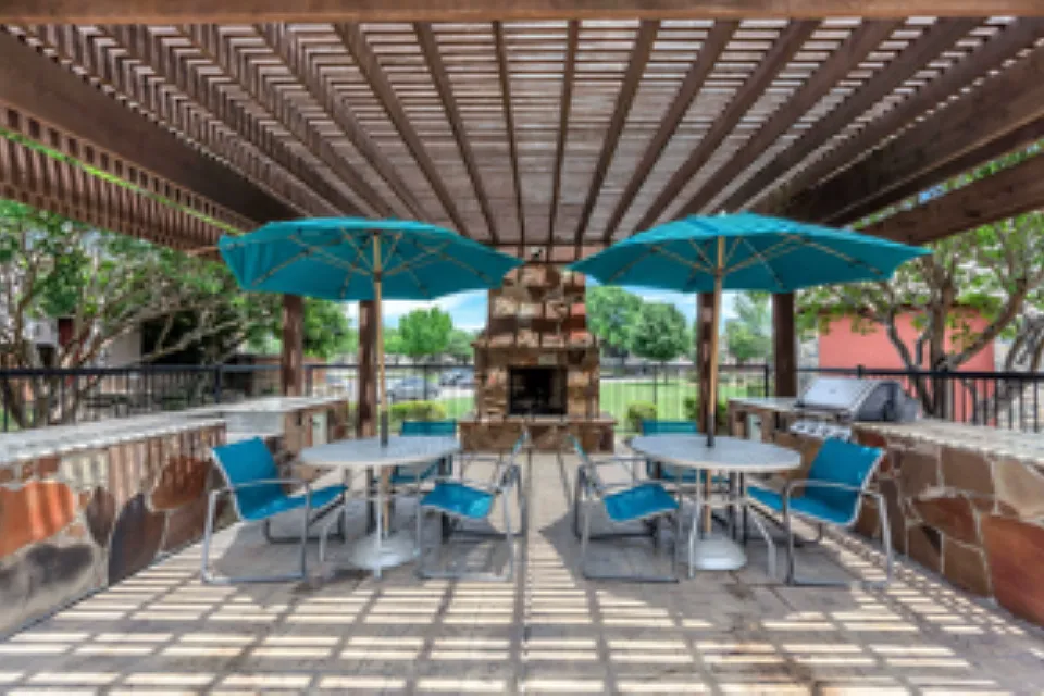 Expansive outdoor cabana with fireplace and grilling station.