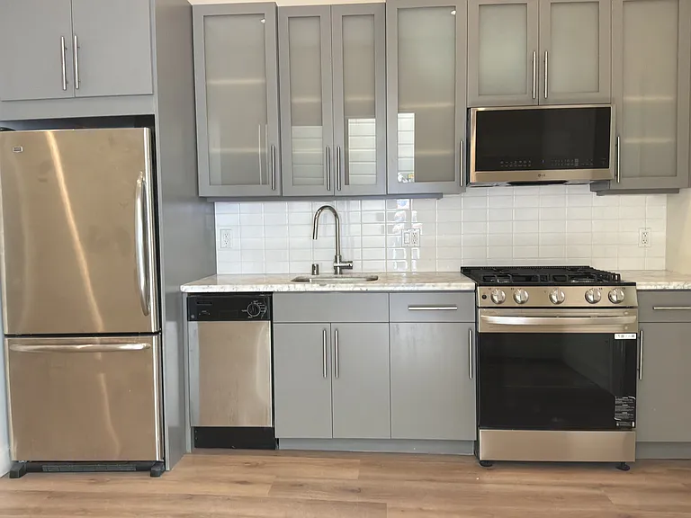 Modern updated kitchen with stainless steel appliances, refrigerator, dishwasher, range, microwave