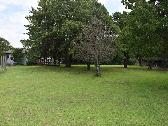 This beautiful fenced back yard is the perfect balance of open space and trees.