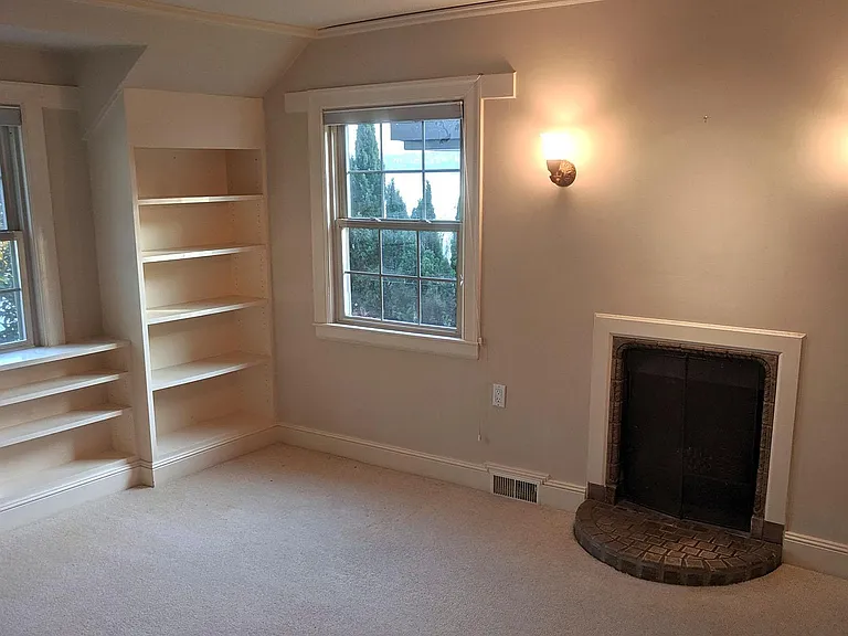 Dressing room has built in bookshelves, fireplace, and multiple closets and bureaus.