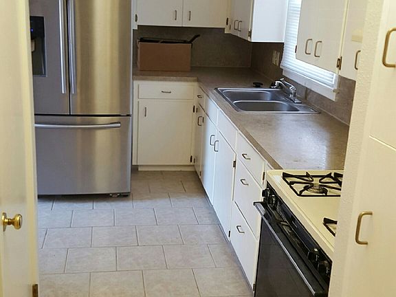 Kitchen with new Stainless Steel Refrigerator. Pantry for food & supply storage.