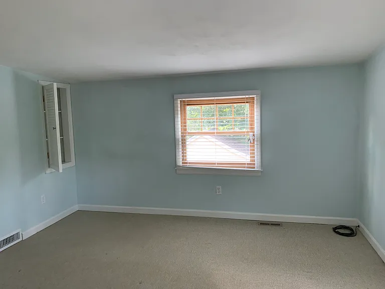 Large primary bedroom with 2 closets and wall storage cabinet.